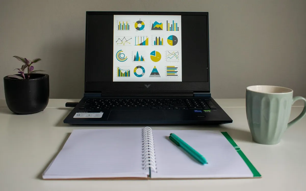 グラフが表示されたノートPCと整理されたデスク